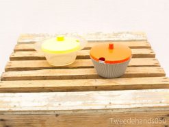 Colorful vintage kitchen bowls on rustic wood, perfect for stylish storage and serving.