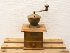 Vintage wooden coffee grinder with brass details, showcasing traditional craftsmanship and nostalgic charm.