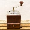 Vintage wooden coffee grinder with metal accents and practical drawer for fresh grounds.