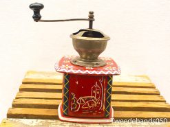 Vintage coffee grinder with colorful wooden box and charming pastoral design. Perfect for collectors.