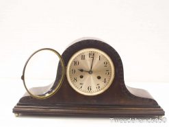 Elegant vintage wooden mantel clock with brass frame and intricate detailing, perfect for any decor.