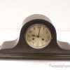 Elegant vintage mantel clock with wooden casing and classic Roman numerals, perfect for any decor.