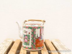 Elegant vintage porcelain teapot with vibrant hand-painted designs and a bamboo handle.