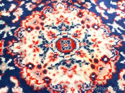 Vintage navy, red, and cream rug with intricate floral patterns and central medallion design.