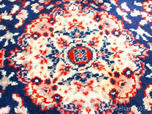 Vintage navy, red, and cream rug with intricate floral patterns and central medallion design.