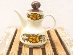 Charming vintage teapot with floral design, perfect for tea lovers and rustic decor.