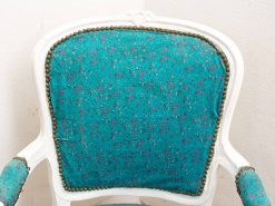 Vintage turquoise floral chair with elegant brass studs and a classic white wooden frame.