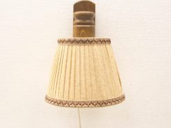 Elegant vintage wall lamp with beige shade and wooden fixture for warm ambiance.