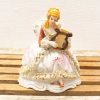 Elegant porcelain lady with harp, vintage decor piece showcasing artistry and charm.