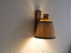 Vintage wall lamp with wooden finish and elegant fabric shade, perfect for cozy interiors.