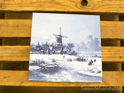 Charming winter scene with a Dutch windmill and cozy houses on a ceramic tile.