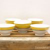 Elegant white bowls with yellow accents, perfect for salads and soups in any dining setting.