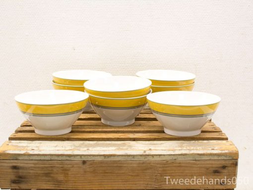 Elegant white bowls with yellow accents, perfect for salads and soups in any dining setting.