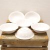 Elegant white bowls arranged on a rustic wooden crate, perfect for any dining occasion.