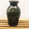 Elegant black ceramic vase with glossy finish and subtle green undertones, perfect for decor.