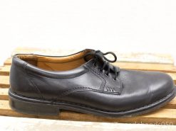 Elegant black leather dress shoe on rustic wooden surface, perfect for formal occasions.