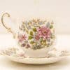 Elegant vintage porcelain teacup and saucer set with vibrant floral patterns and gold accents.