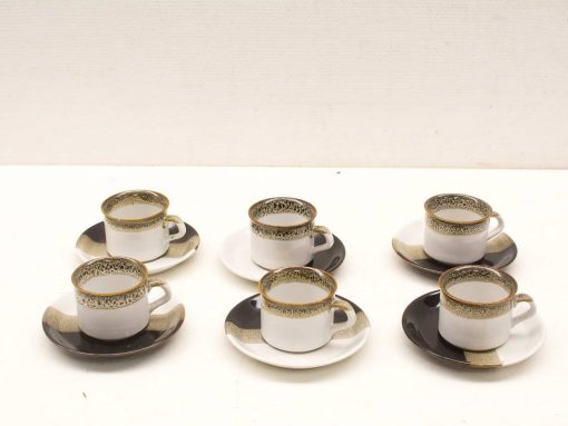 Elegant vintage coffee cups and saucers set with intricate patterns and gold accents.