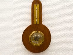 Antique wooden barometer and thermometer with vintage charm and elegant craftsmanship.