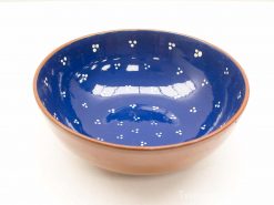 Handcrafted ceramic bowl with glossy blue interior and rustic brown exterior, featuring delicate white dots.