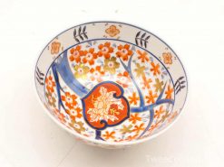 Vibrant floral ceramic bowl, hand-painted in red, gold, and blue, perfect for decor or use.