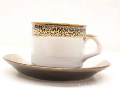 Elegant ceramic coffee cup and saucer set with rustic charm and modern simplicity.