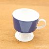 Elegant blue ceramic cup with white base and handle, perfect for any occasion.