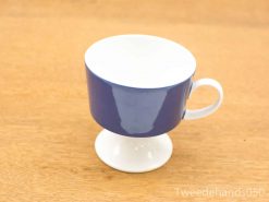 Elegant blue ceramic cup with white base and handle, perfect for any occasion.