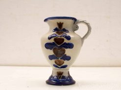 Handcrafted ceramic jug featuring blue hearts and floral designs, perfect for any decor.