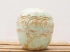 Handmade blue-green ceramic pot with intricate wave design, perfect for decor or plants.