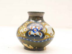 Elegant ceramic vase with vibrant floral patterns in green, blue, and earthy tones.