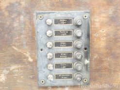 Vintage marine control panel with essential function switches for safe boating operations.