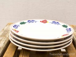 Decorative floral plates stacked on rustic wood surface, enhancing cozy dining atmospheres.