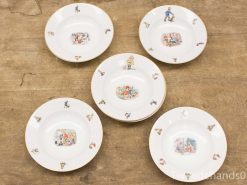 Vintage decorative plates with whimsical illustrations of children and animals, perfect for display.