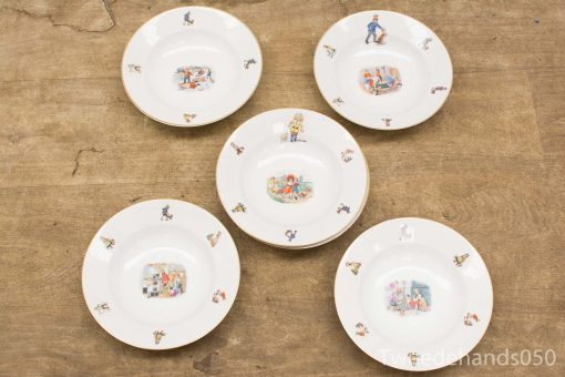 Vintage decorative plates with whimsical illustrations of children and animals, perfect for display.