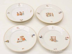 Charming decorative plates featuring whimsical childhood scenes in pastel colors and elegant gold trim.