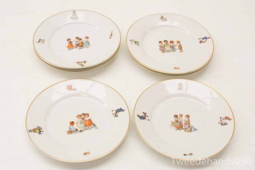 Charming decorative plates featuring whimsical childhood scenes in pastel colors and elegant gold trim.