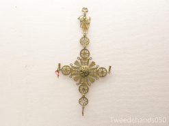 Antique decorative cross with filigree, floral motifs, and candle holders for spiritual display.