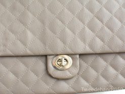 Stylish beige quilted handbag with silver clasp, perfect for any occasion.