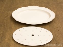 Elegant oval serving platter and perforated dish set for versatile dining and cooking needs.