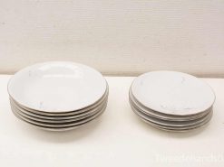 Elegant white plate set for stylish dining, featuring six large and three small plates.