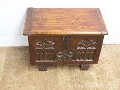 Elegant wooden chest with gothic carvings, perfect for storage and decoration in any room.