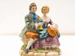 Charming vintage ceramic couple figurine exuding elegance and romance in soft pastel colors.