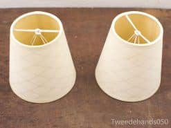 Elegant off-white lamp shades on a rustic wooden surface, enhancing cozy home decor.