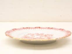 Elegant porcelain plate with red floral design and gold scalloped edge for special occasions.