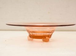 Elegant pink vintage glass plate with artistic claw feet, perfect for dining and decoration.