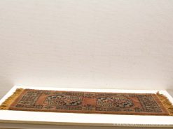 Handwoven vintage rug with rustic patterns in warm rust and brown tones.