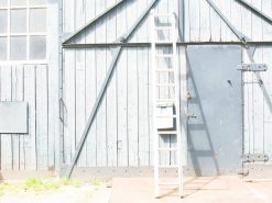 Rustic wooden barn with blue paint, metal ladder, and charming vintage character.