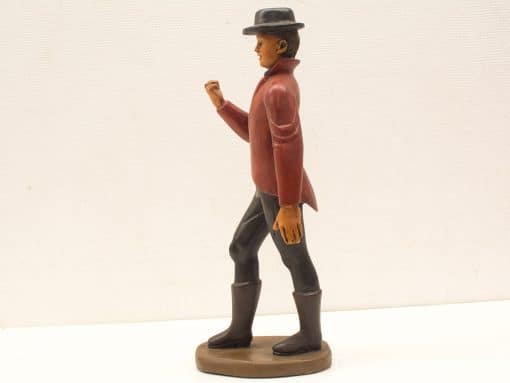 Vintage figurine of a charismatic man in a red jacket and fedora, exuding adventure.