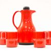 Red ceramic coffee pot set with four matching mugs, perfect for stylish coffee moments.